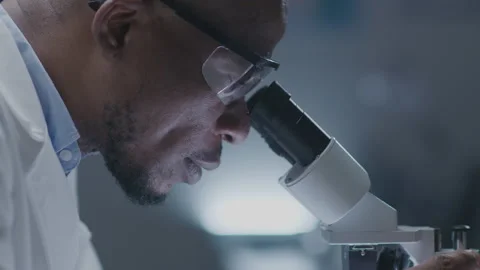 Black Scientist Looking in Microscope Stock Footage 236419790