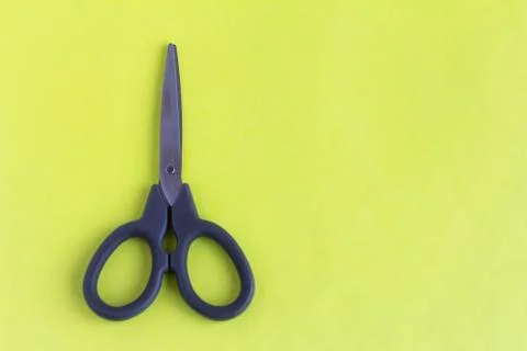Black scissors on a yellow background.Small scissors for cutting. Stock Photos