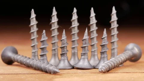 Black screws are beautifully placed on a wooden table. Moving camera macro Stock Footage 73394012