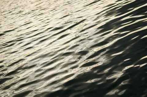 Black sea surface background with waves. Silky texture of ocean water. Stock Photos