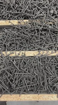 Black self-tapping screws in the store on the counter. Stock Photos