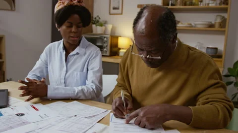 Black Senior Man Writing Checks and Paying Bills Video stock 327684597