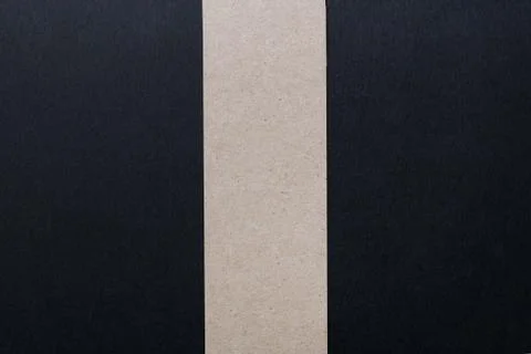 A black sheet of paper divided in half by a vertical stripe of kraft paper Fotos Stock