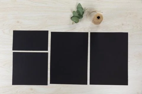 Black sheet of papers surrounded by a flower and a knitting yarn on wood table Stock Photos