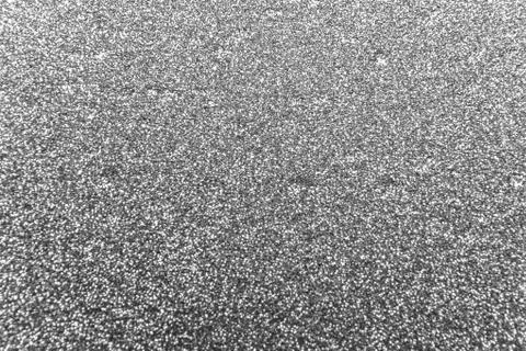 Black shimmer glitter background with bumpy textured Stock Photos