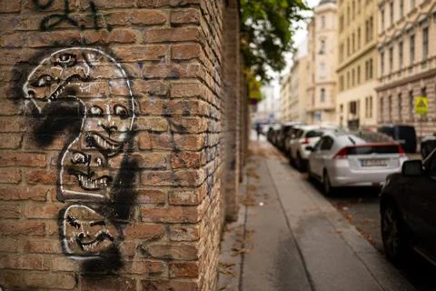 Black silhouette face mural with question mark on yellow brick corner wall .. Stock Photos