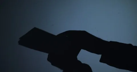 Black silhouette of hands counting banknotes on blue background 스톡 동영상 123493679