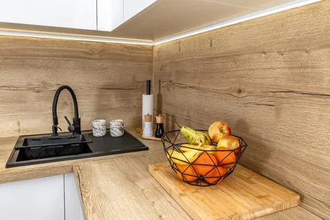 A black sink with an adjustable tap, a salt and pepper container placed on .. Stock Photos