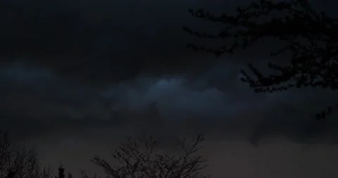 Black sky full of storm clouds with orange haze ready for a thunderstorm Stock Footage 205448494