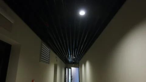 Black slatted ceiling with integrated lighting in residential corridor Video stock 343515406