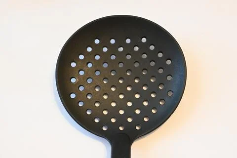 Black slotted spoon on a white background Stockfoto's