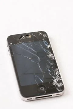 Black smartphone with crashed lcd touch screen above white marble background Stock Photos