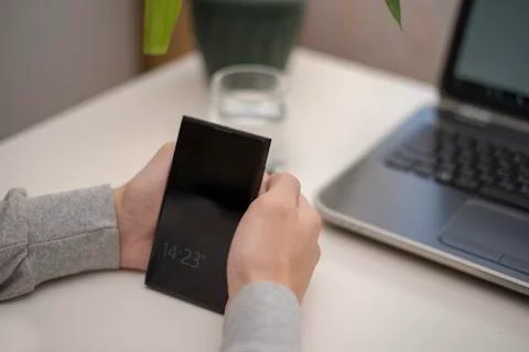Black smartphone in the hands of the unknown Stock Photos