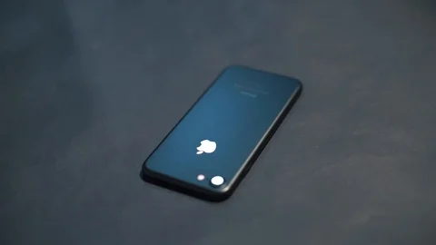A black smartphone lies on a black surface in the workshop. Stock Footage 121949433