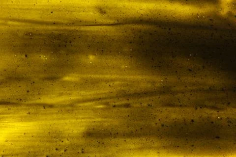 Black smears charcoal toothpaste over yellow board, abstract background Stock Photos