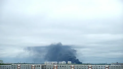 Black smoke billows on background over apartment buildings in modern city. Stock Footage 309188860