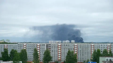 Black smoke billows on background over panel apartment buildings in modern city. Stock Footage 309189166