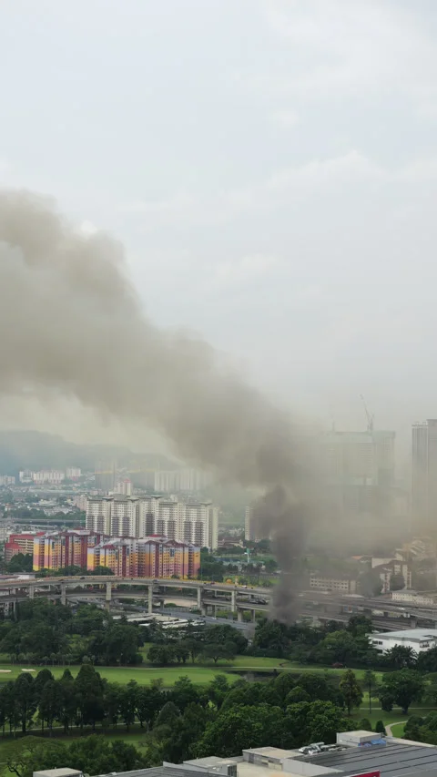 Black smoke cloud billowing from fire in city area, vertical shot Stock Footage 345644877
