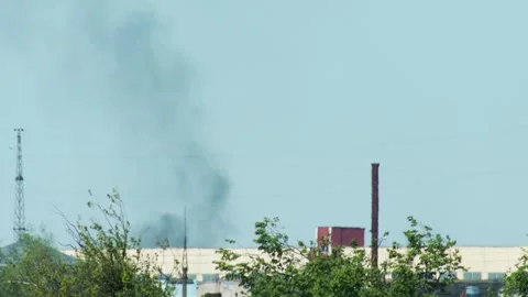 Black smoke from a fire against a blue sky, against the backdrop of buildings Video stock 314888296