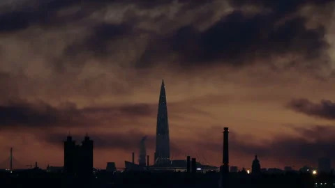 Black smoke flies on the wind over an industrial city with a large tower Stock Footage 137922162