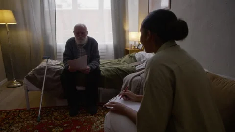 Black Social Worker Helping Elderly Man to Apply for Financial Support Stock Footage 329681878
