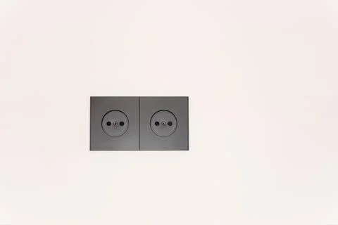 Black Sockets in the wall, wires in the socket on the kitchen wall, overloaded Stock Photos
