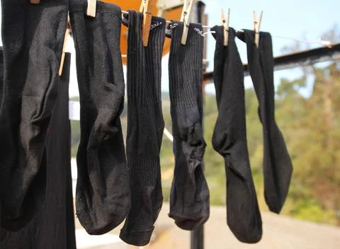 Black socks lying down (hanging out the laundry) Stock Photos