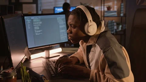 Black Software Developer Wearing Headphones Coding on Computer at Night Video stock 336711205