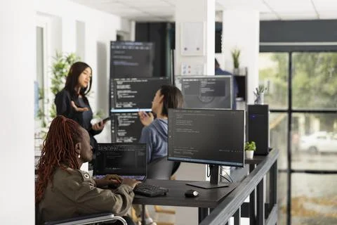 Black software developer in wheelchair analyzing code on computer 写真素材
