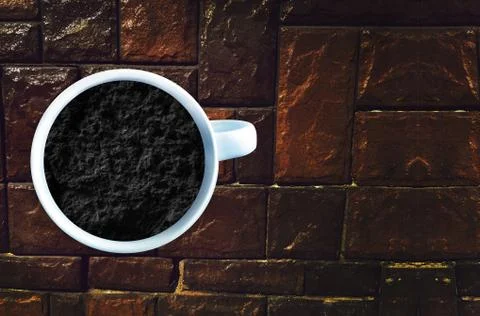 Black soil in white cup. Creative idea Stock Photos