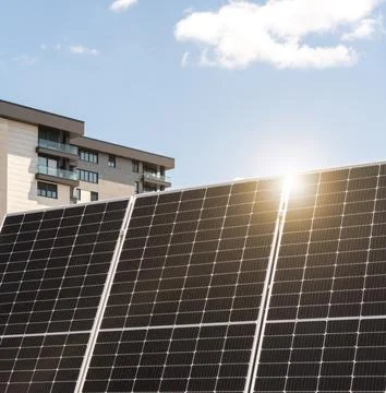 Black solar panel in front of rooftop of residential house in city Foto stock