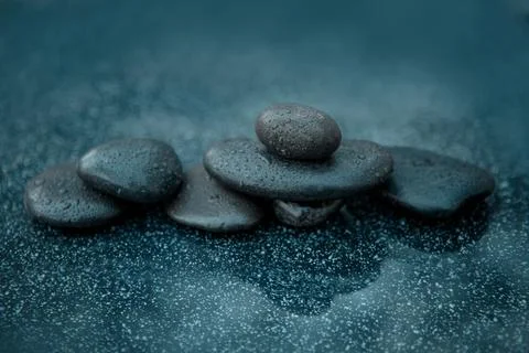 Black spa stones on the gray table background. Stock Photos