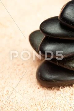A black spa stones on the towel Stock Photos