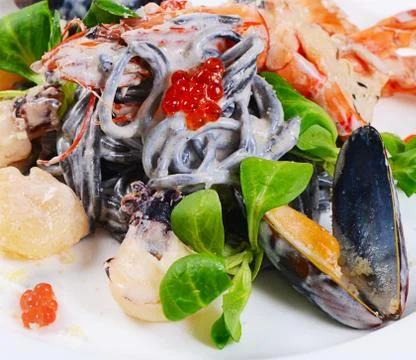 The black spaghetti with seafood closeup Stock Photos