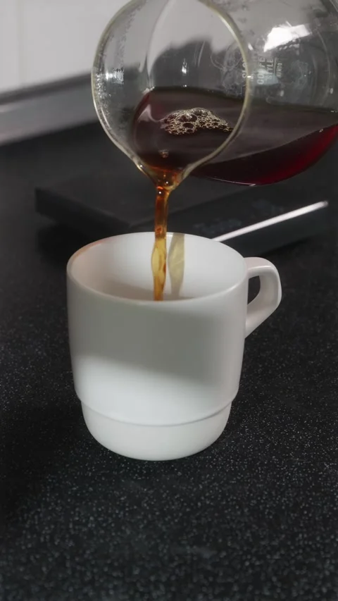 Black specialty coffee in a white ceramic mug vertical Video stock 338395150
