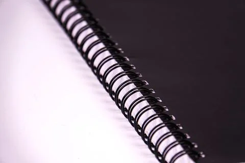 Black spiral notebook binding close-up focus, showcasing metallic sheen, refl Stock Photos