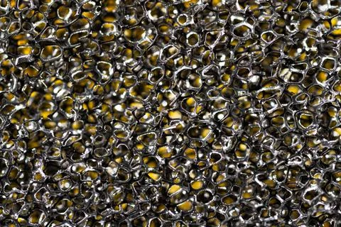 Black sponge macro abstraction texture on a yellow background 写真素材