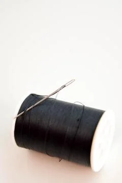 Black spool of thread and needle Stock Photos