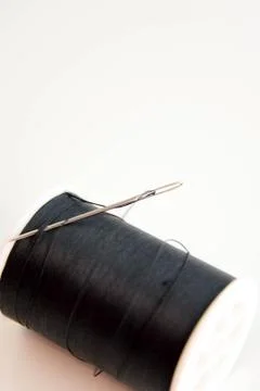Black spool of thread and needle Stock Photos