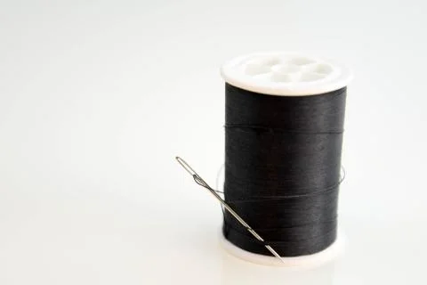 Black spool of thread and needle Stock Photos
