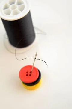 Black spool of thread, needle and buttons Stock Photos