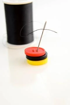 Black spool of thread, needle and buttons Stock Photos