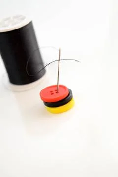 Black spool of thread, needle and buttons Stock Photos