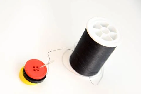 Black spool of thread, needle and buttons Foto stock