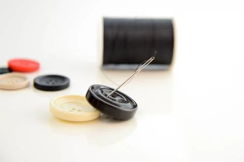 Black spool of thread, needle and butons Stock Photos