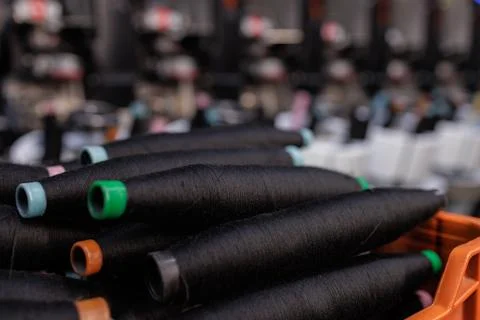 Black Spools of Thread on Yarn Production Line Closeup Textile Industry Man.. Stock Photos