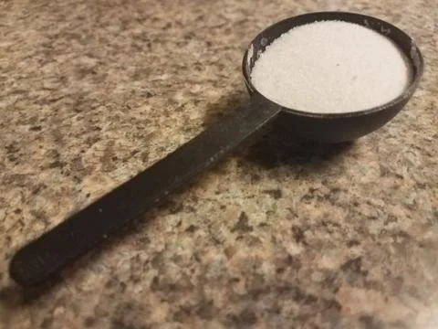 Black spoon with sugar Stock Photos