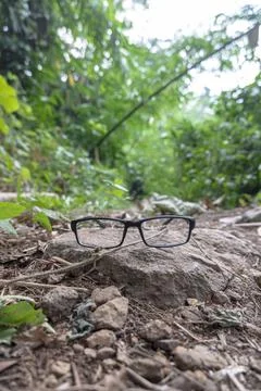 Black square eyeglass frames on stone. square eyeglass frames in the photo fr Stock Photos