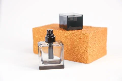 Black square perfume bottle, golden rectangular shape on white background Stock Photos
