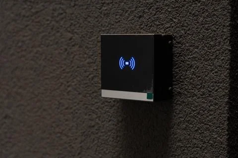 Black square smart home device with blue wireless signal icon mounted on da.. Stock Photos